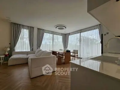 Spacious modern living room with large windows and elegant decor
