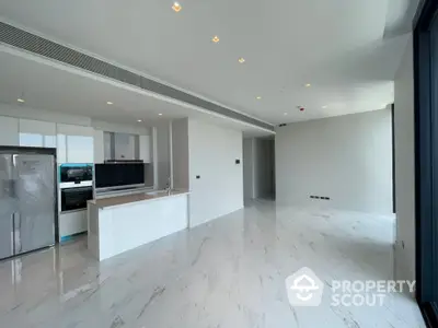 Modern open-plan kitchen with sleek white cabinetry and marble flooring in a luxury apartment.