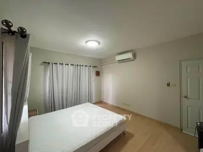 Spacious bedroom with modern air conditioning and natural light, perfect for comfort and relaxation.
