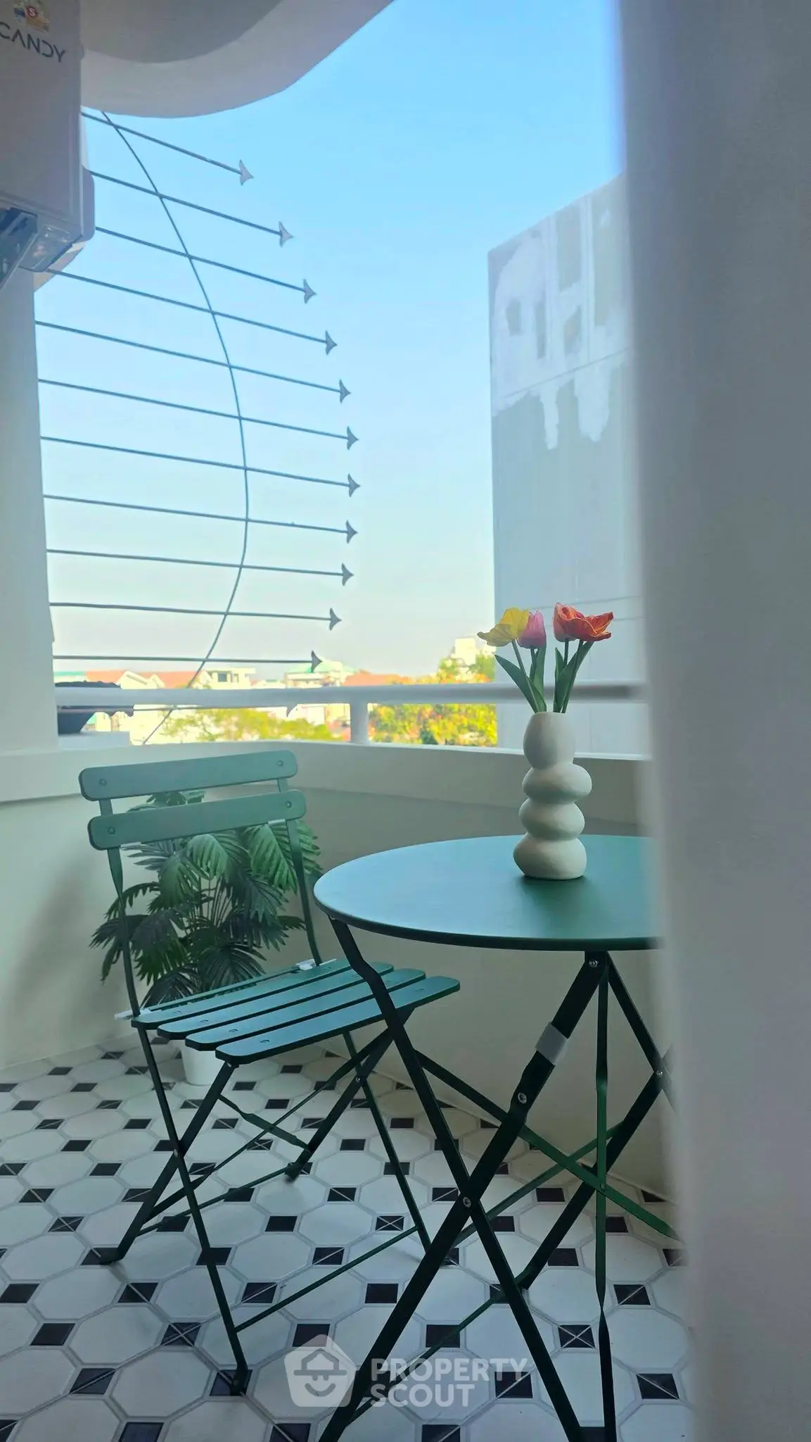 Charming balcony with stylish seating and city view, perfect for relaxation.