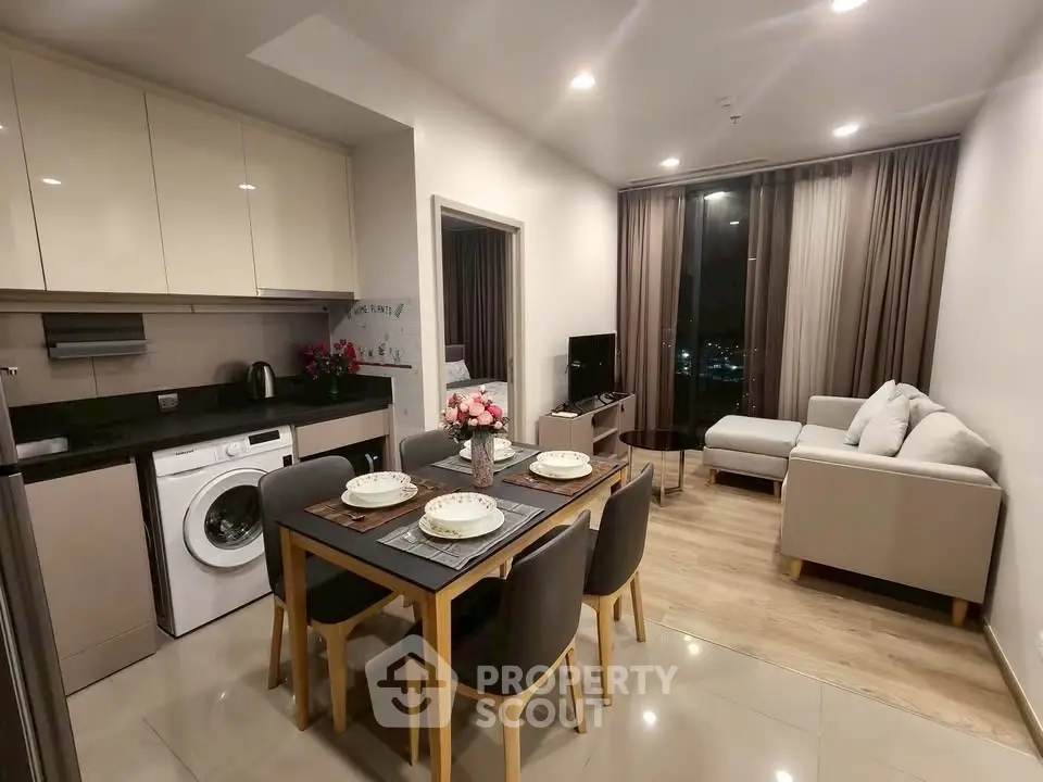 Modern open-plan living room and kitchen with elegant decor and city view.