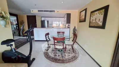 Spacious open-plan living area with modern kitchen and dining set, featuring exercise equipment for a healthy lifestyle.