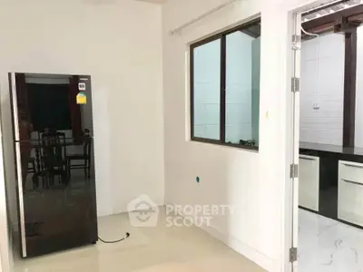 Modern kitchen space with sleek black refrigerator and open layout design.