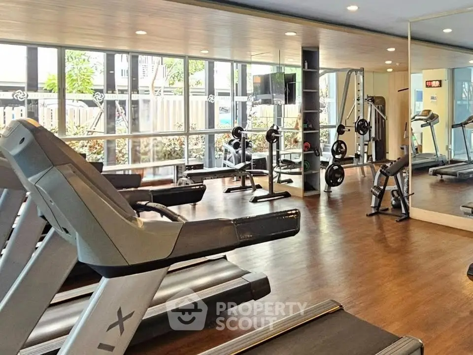 Modern gym with state-of-the-art equipment and large windows for natural light.