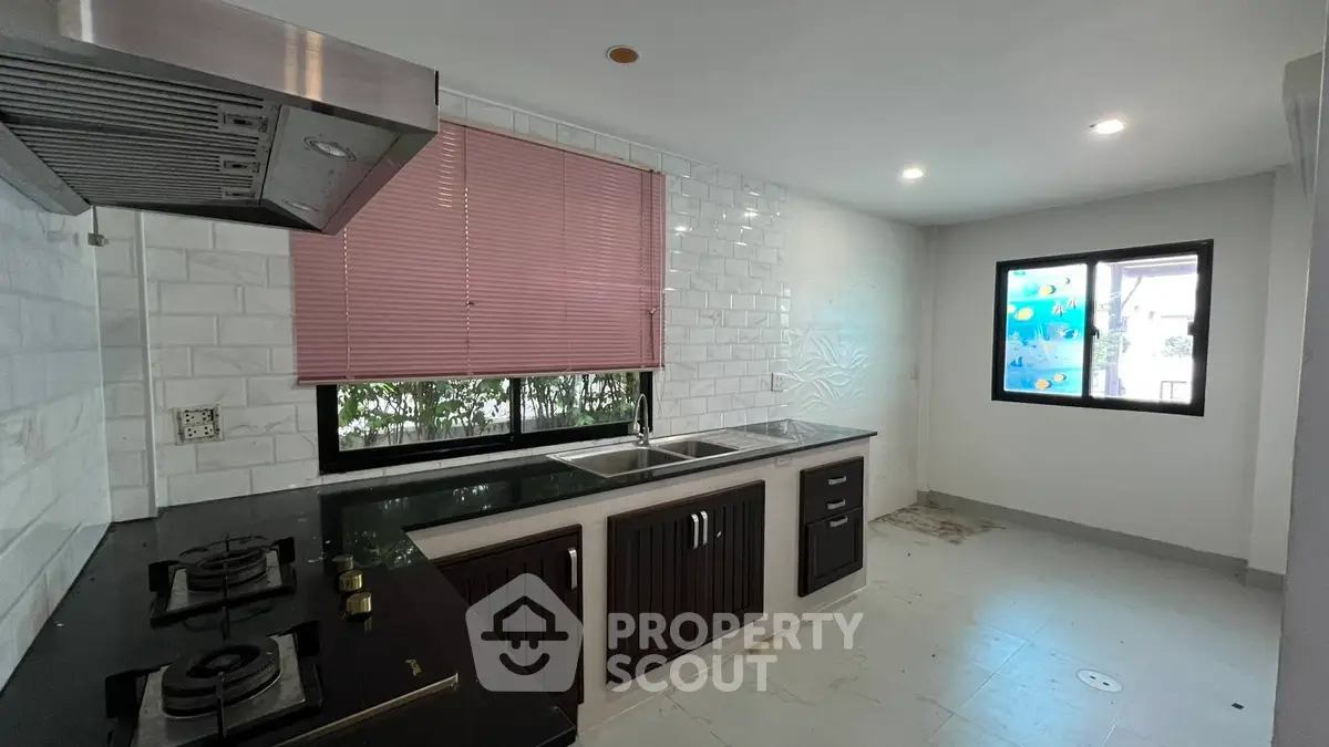 Modern kitchen with gas stove and sleek cabinetry in bright, airy space.