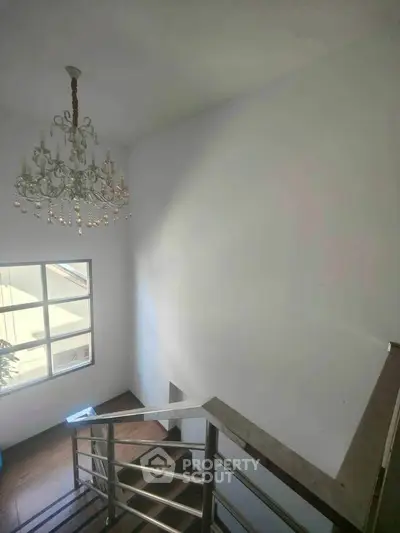 Elegant staircase with chandelier and natural light in modern home