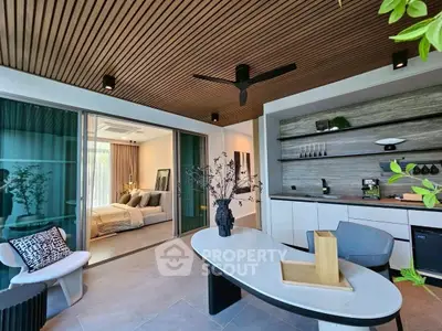 Modern open-concept living room with stylish decor and adjacent bedroom view.