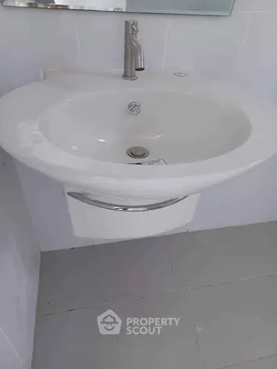 Modern bathroom sink with sleek design and chrome faucet in a minimalist setting.