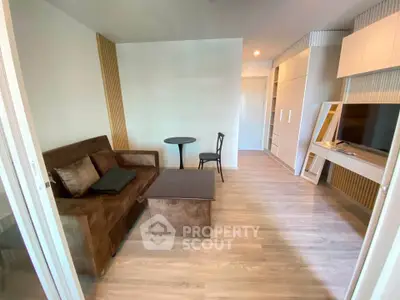Modern living room with sleek furniture and wooden flooring in a stylish apartment.