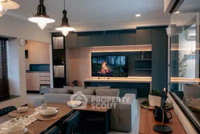 Modern living room with stylish decor and large TV, perfect for relaxation.