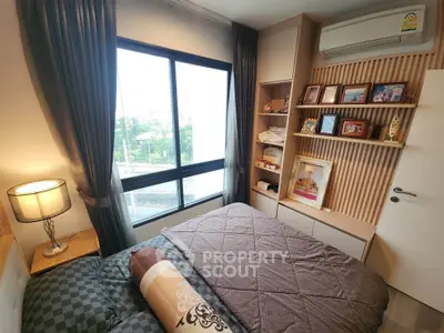 Cozy bedroom with large window and stylish decor in modern apartment