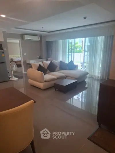 Spacious living room with modern furniture and balcony view in a stylish apartment.