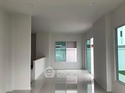 Spacious modern living room with large windows and sleek tile flooring