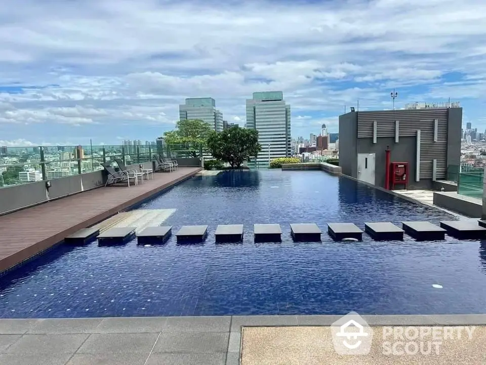 Luxurious rooftop pool with stunning city skyline views in modern urban setting.