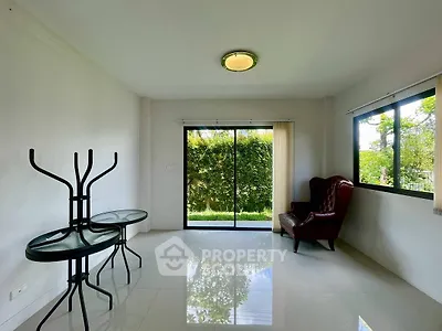 Spacious living room with garden view and elegant armchair