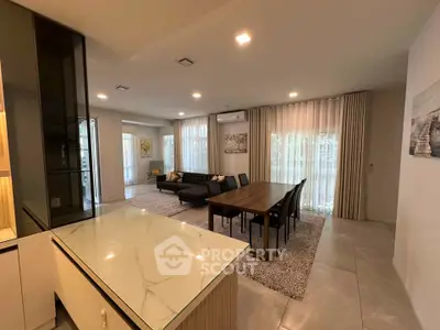 Spacious modern living room with elegant dining area and large windows for natural light.