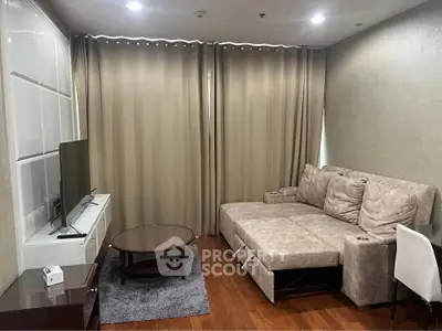 Modern living room with cozy sectional sofa and flat-screen TV, featuring elegant curtains and wooden flooring.