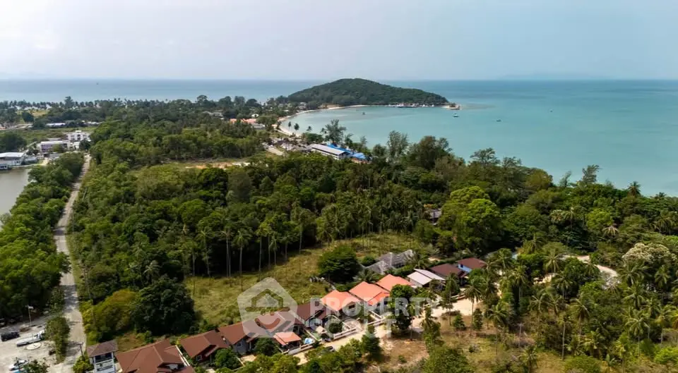 Stunning aerial view of beachfront properties surrounded by lush greenery and ocean views.