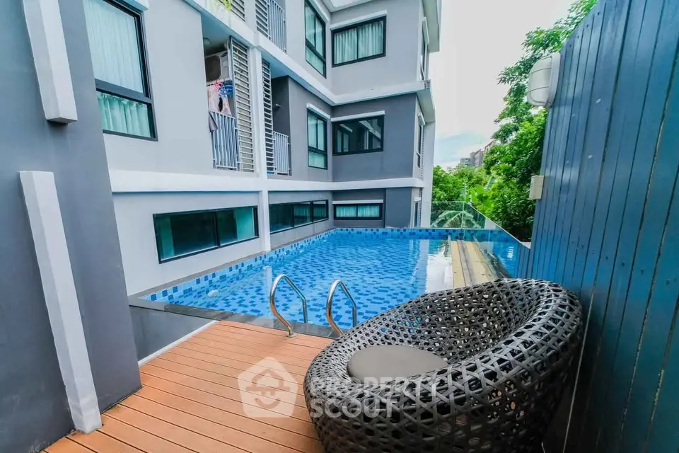 Modern apartment with poolside seating and sleek architectural design.