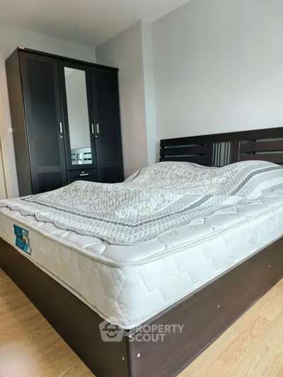 Cozy bedroom with modern dark wood furniture and comfortable mattress.
