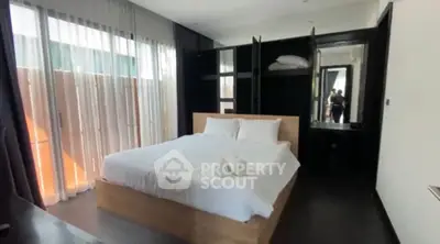 Luxurious bedroom with modern design and ample natural light, featuring a cozy bed and elegant decor.