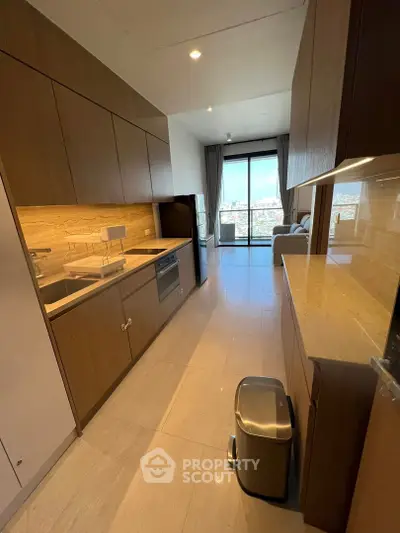 Modern kitchen with sleek cabinetry and open layout leading to a bright living area with city views.