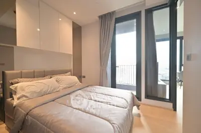 Modern bedroom with balcony access and stylish decor in a luxury apartment.