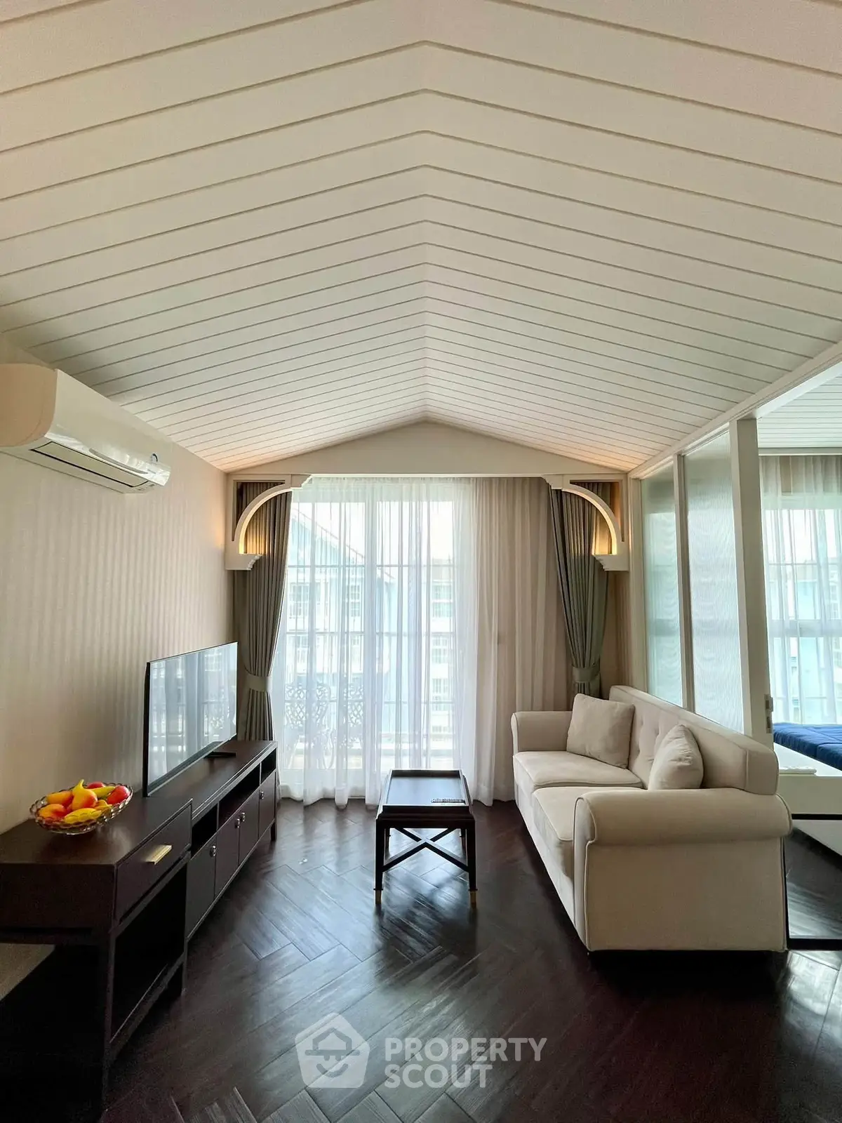 Elegant living room with modern decor, large windows, and stylish ceiling design in a luxury apartment.