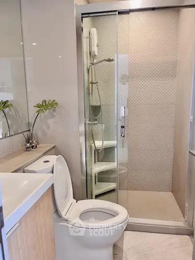 Modern bathroom with glass shower and sleek fixtures in a contemporary apartment.