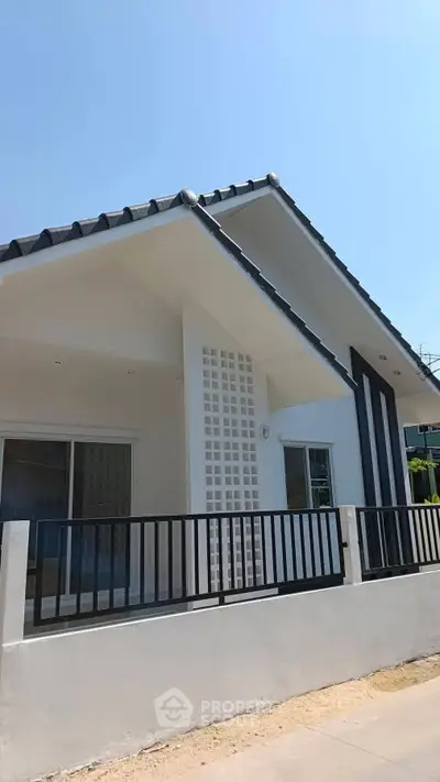 Modern single-story house with sleek design and spacious front yard.