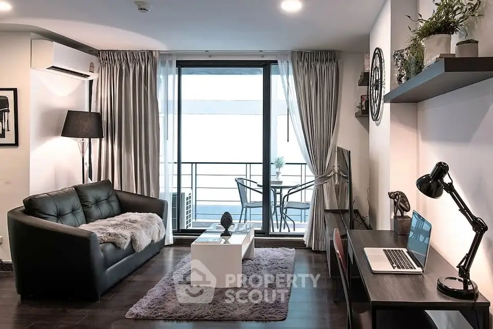 Modern living room with balcony access, featuring stylish furniture and a cozy ambiance.