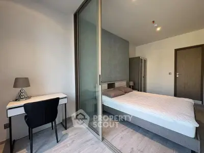Modern bedroom with sliding glass doors and a cozy workspace