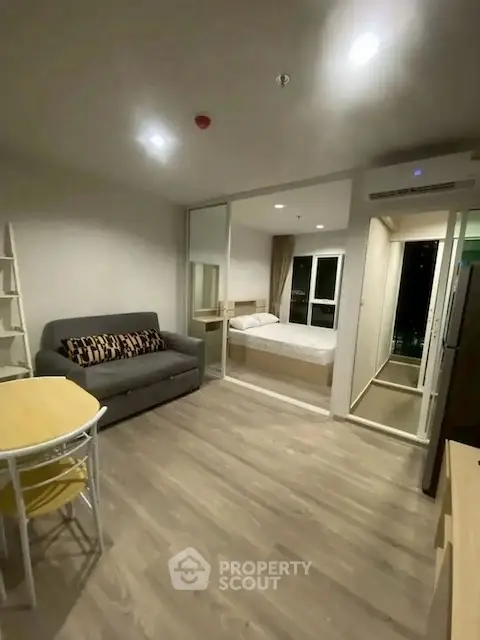 Modern studio apartment with open layout featuring cozy living area and bedroom.