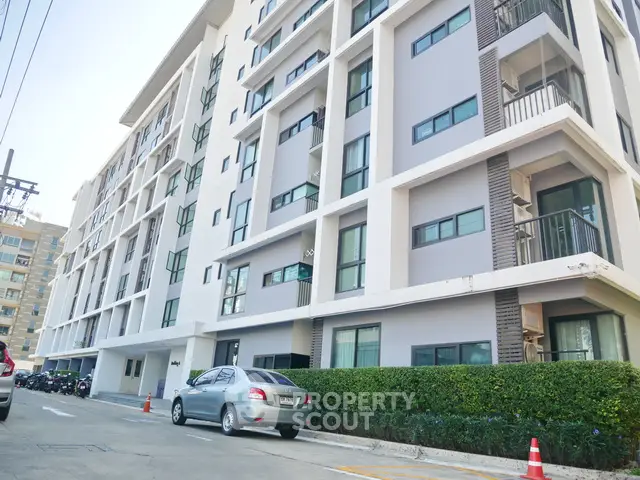 Modern apartment building exterior with clean lines and lush greenery