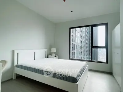 Modern minimalist bedroom with large window and city view