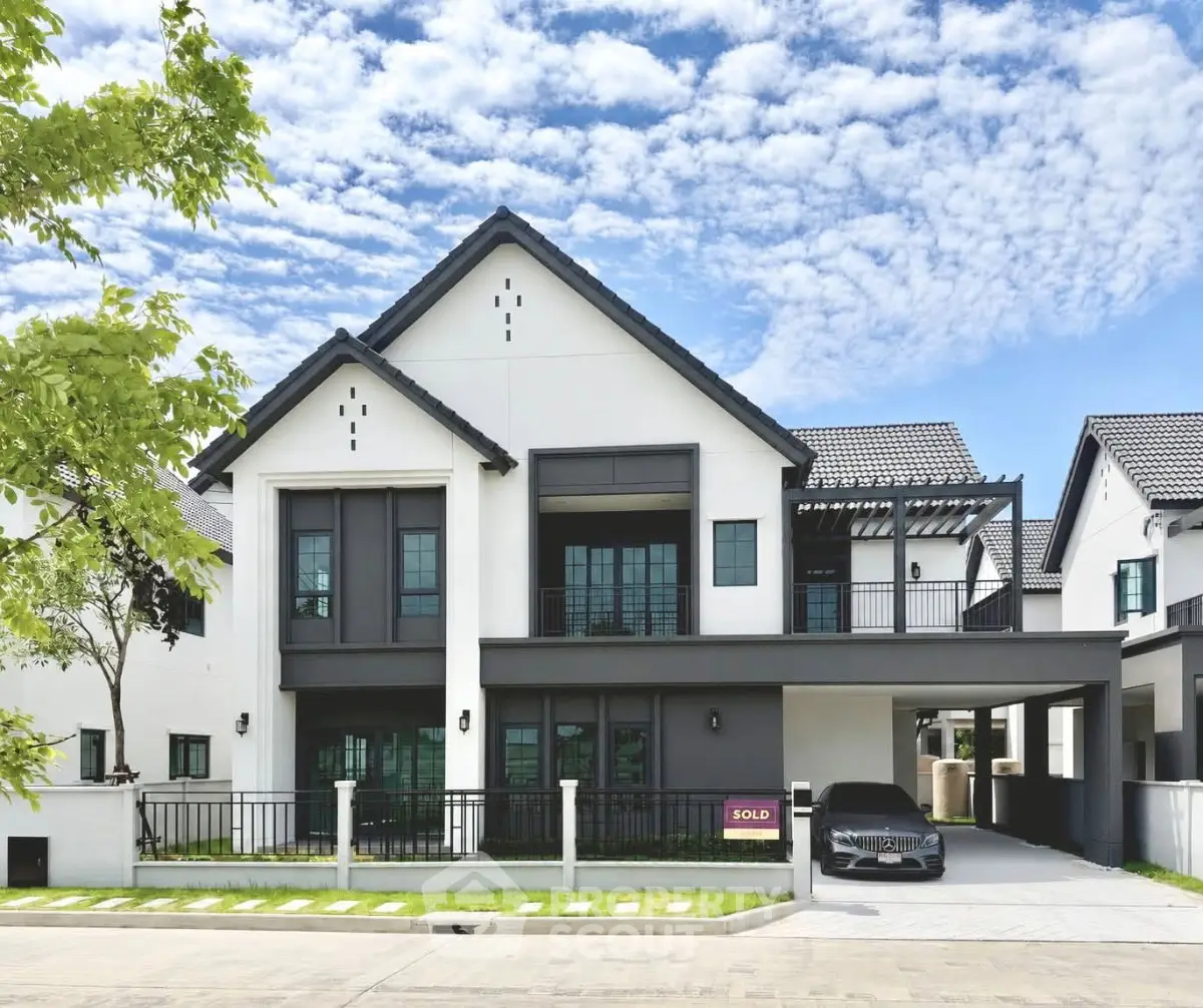 Stunning modern house with sleek design and sold sign, perfect for luxury living.