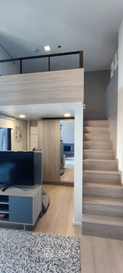 Modern loft apartment with stylish wooden staircase and open living area, perfect for urban living.