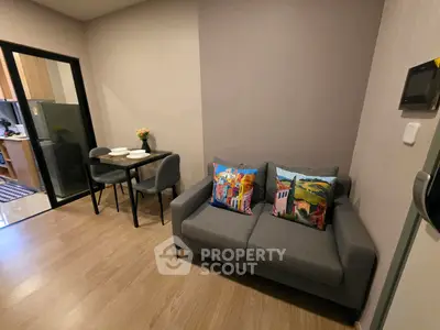 Cozy living room with modern decor and dining area in a stylish apartment.