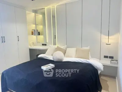 Modern bedroom with sleek built-in storage and cozy bedding in a minimalist design.