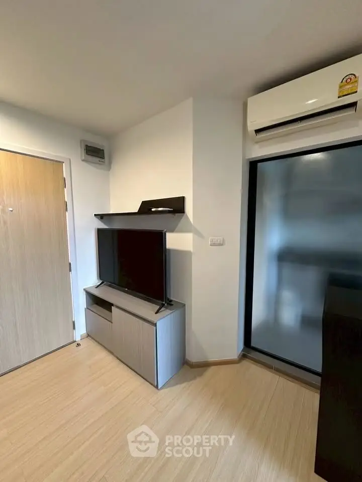 Modern living room with sleek TV stand and air conditioning unit, featuring minimalist design and wooden flooring.