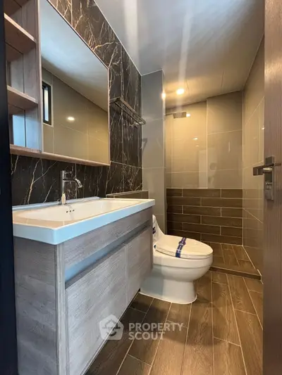 Modern bathroom with wooden accents and sleek fixtures in a contemporary home.