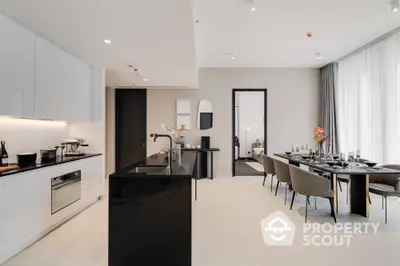 Luxurious modern kitchen and dining area with sleek black countertops and elegant decor.