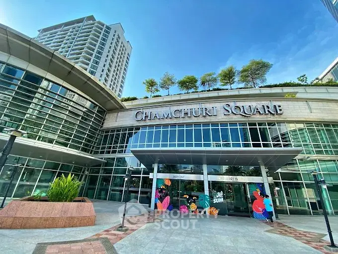 Modern commercial building exterior with glass facade and lush rooftop garden at Chamchuri Square.