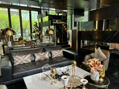 Luxurious modern living room with elegant decor and large windows offering a garden view.