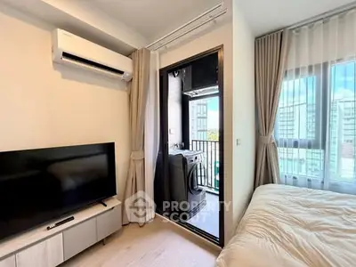 Modern bedroom with balcony and washing machine, featuring sleek design and natural light.