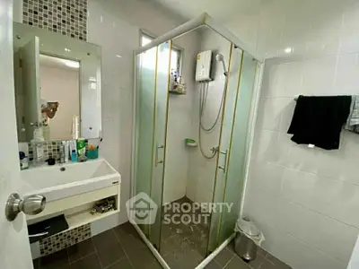 Modern bathroom with glass shower enclosure and sleek vanity in a contemporary home.