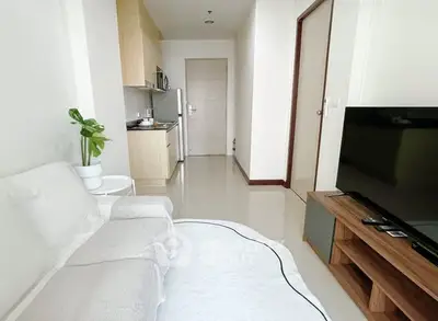 Modern living room with sleek kitchen and cozy seating area in a stylish apartment.