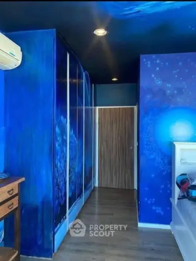 Vibrant blue-themed bedroom with unique wall art and wooden flooring