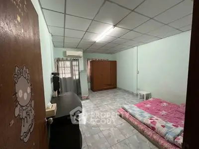 Spacious bedroom with tiled floor, air conditioning, and simple furnishings for comfort.