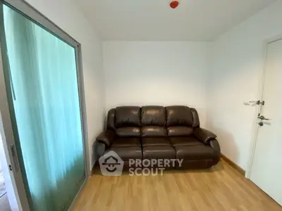 Cozy small living room with leather sofa and wooden flooring